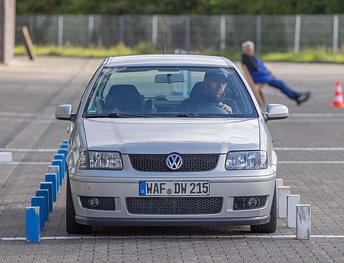 Ein männlicher Fahrer sitzt am Steuer eines Volkswagen PKW.