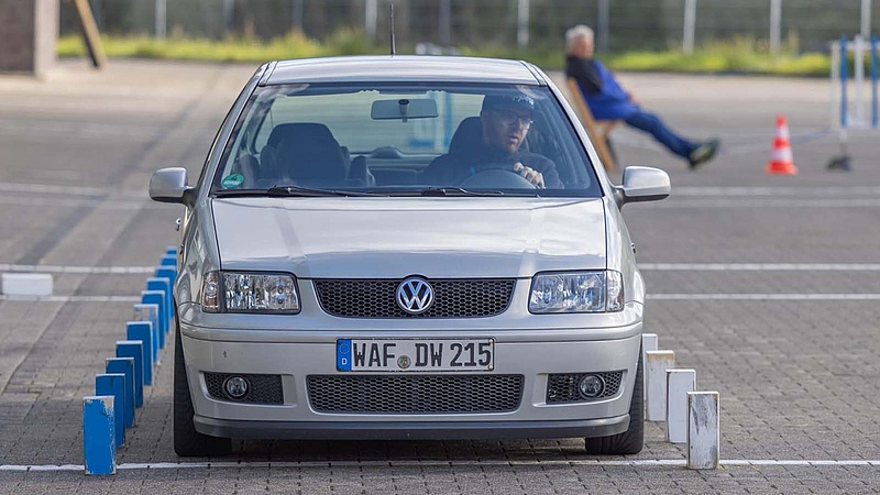Ein männlicher Fahrer sitzt am Steuer eines Volkswagen PKW.